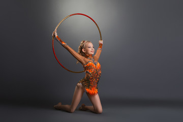 Gymnast girl performing with hoop at studio