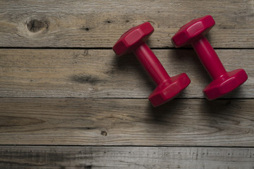 Two of red dumbbells on the wood table