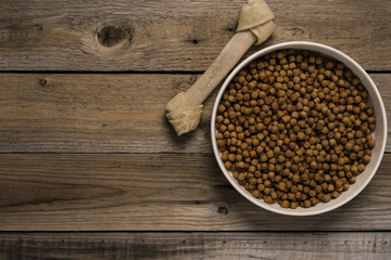 Dog bone and dog food on wood table