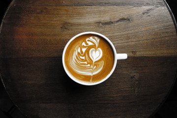 cup of latte art coffee on wooden background