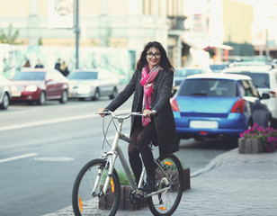 Fototapeta na wymiar Pretty young woman riding bike outdoors