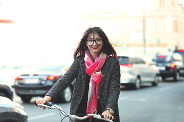 Fototapeta premium Pretty young woman riding bike outdoors