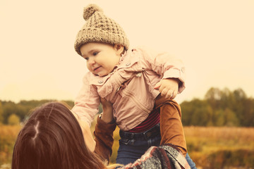 Happy mother with child outdoors in autumn day