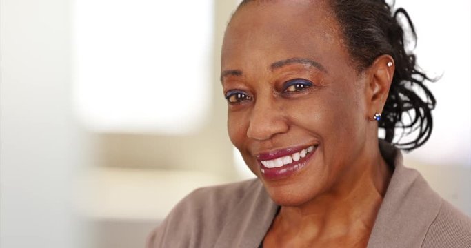 Close-up of a smiling elderly African American woman at work. An older black businesswoman happily posing for a portrait
