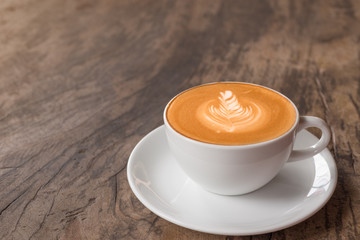 cup of latte coffee on wooden vintage table.
