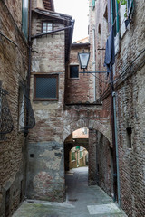 Fototapeta na wymiar arches between old buildings in Siena