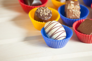 lot of variety chocolate pralines on wood background