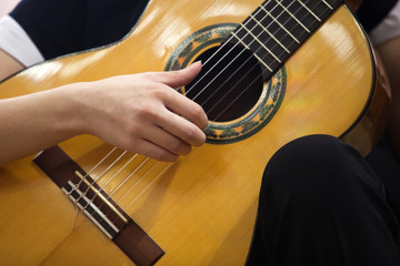 Hand girl playing guitar closeup