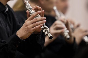 Hands musician playing the flute in the orchestra closeup