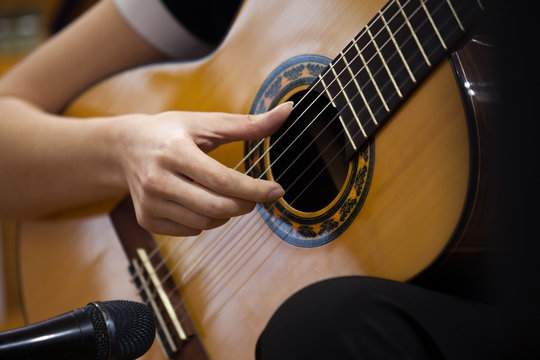  Hand girl playing guitar closeup
