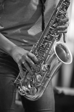 Hands girl playing the saxophone in black and white