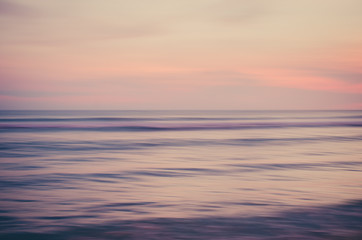 Naklejka na ściany i meble Motion blur tropical sunset beach with bokeh sun light wave abstract background.