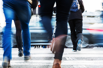 hurried people crossing a city street