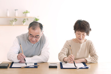 Obraz premium 書道をするシニア夫婦