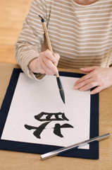 書道をするシニア女性の手元