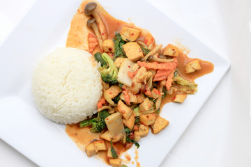 Stir Fried Tofu with Gravy Sauce and mixed vegetables in white plate on white background. Vegetarian Food, healthy food.