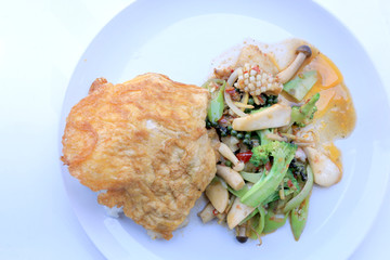 Stir fried Spicy Seafood with black pepper and thai style omelette with rice on white dish,  Thai spicy herb food / Image select focus