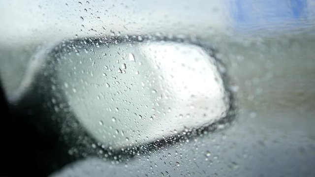 View of the road in the rearview mirror of a car on rainy autumn straight road - wedding motorcade