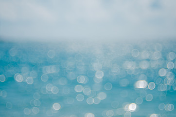 Blur tropical beach with bokeh sun light wave abstract background.