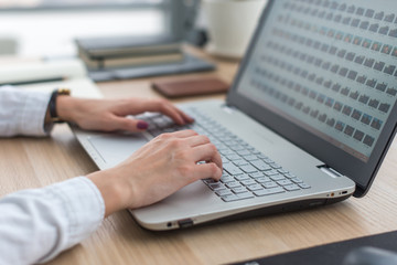 Fototapeta premium Working with laptop woman writing a blog. Female hands on the keyboard.