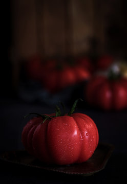 Red tomatoes on black background