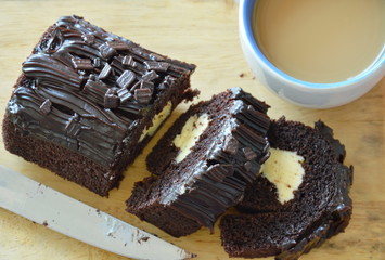dark chocolate jam roll stuffed cream eat couple with coffee on wooden chop block