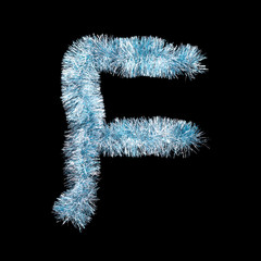 Festive alphabet made of blue tinsel. Letter F on black background. Isolated