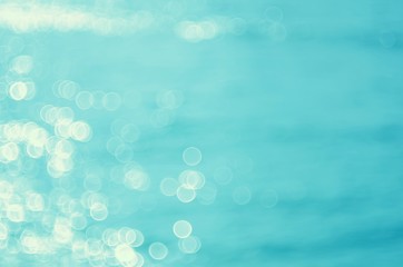 Blur tropical sunset beach with bokeh sun light wave abstract background.