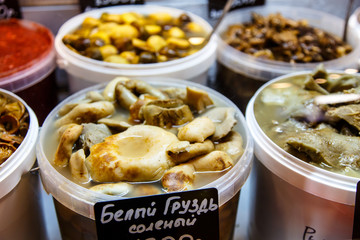 Russian products, pickled mushrooms in buckets on the counter of