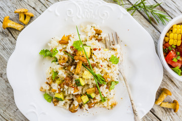 Top view of risotto with chanterelle mushrooms on rustic wooden table. 