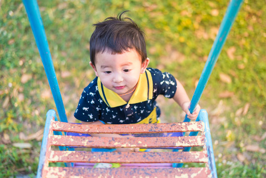 Asian Kid Goes Up The Stairs In The Park. Concept Of Growing Up.