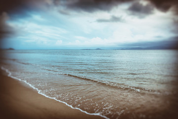 background of blurred beach and sea waves with bokeh lights, san