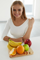 Beautiful Woman With Fruits In Kitchen. Nutrition And Vitamins