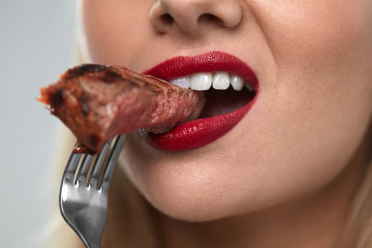 Eating Meat. Closeup Of Sexy Woman's Mouth Biting Tasty Meat
