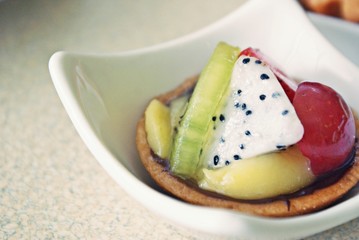 Delicious fruit tart with dragon fruits, kiwi, grapes, pineapple and cheese.
