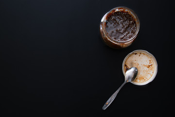 Glass Jar Full Of Fig Jam On Black Background.