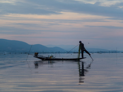 Unrecognizable fishermen in sunrise at Lake Inle