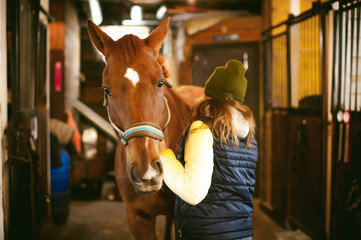 Female rider trains the horse out of the stables