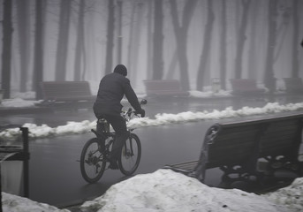 Man on bike rides in the winter park