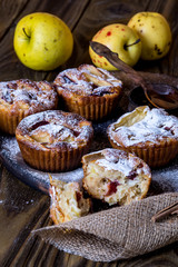 Apple muffins with bowl of honey on wood background