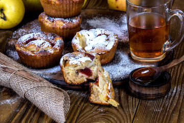 Apple muffins with bowl of honey on wood background