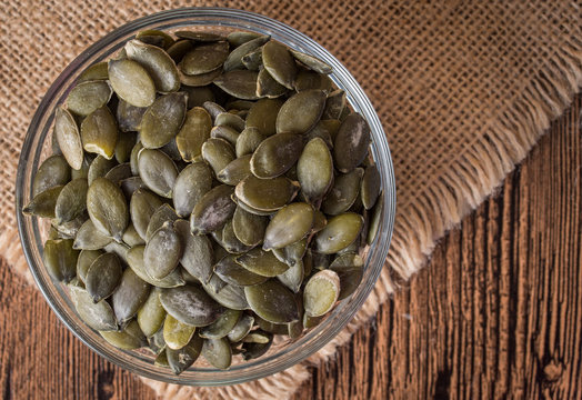Pumpkin seeds on rustic background. Top view