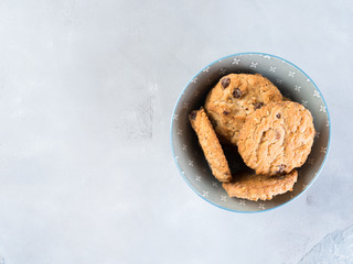 Chocolate chip cookies in bowl on gray textured background. Winter home made sweet food snack