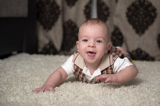 Cheerful baby on the rug