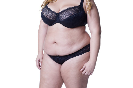 Plus size model in black lingerie, overweight female body, fat woman with stretch marks isolated on white background