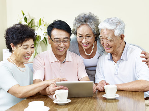 two senior asian couple using tablet computer