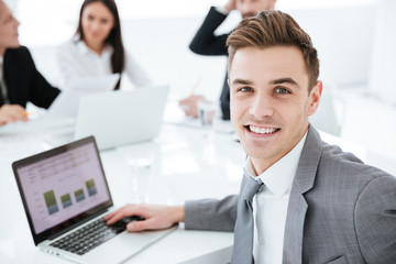 Fototapeta premium Portrait of business man by the table with colleagues