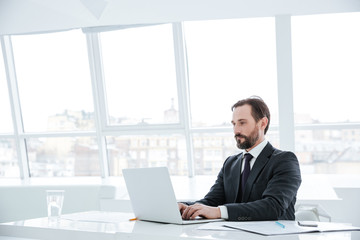 Side view of Elderly bearded business man by the table