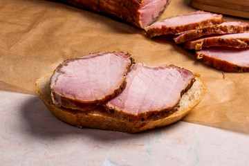 Slices smoked meat or ham on brown packing paper. Slices white w
