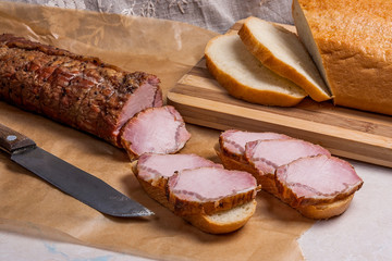Slices smoked meat or ham on brown packing paper. Slices white w